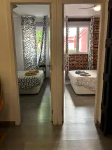 Puertas abiertas que dan a los dos dormitorios dobles del apartamento con camas y toallas preparadas